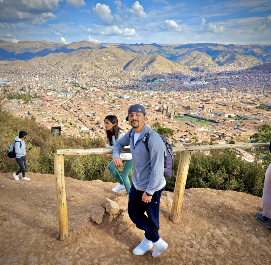 Rich Morales, founder of An Honest Voyage, standing at an overlook above a mountain city